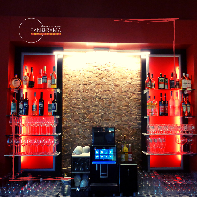 Beleuchtete Bar mit Spirituosen und Natursteinwand